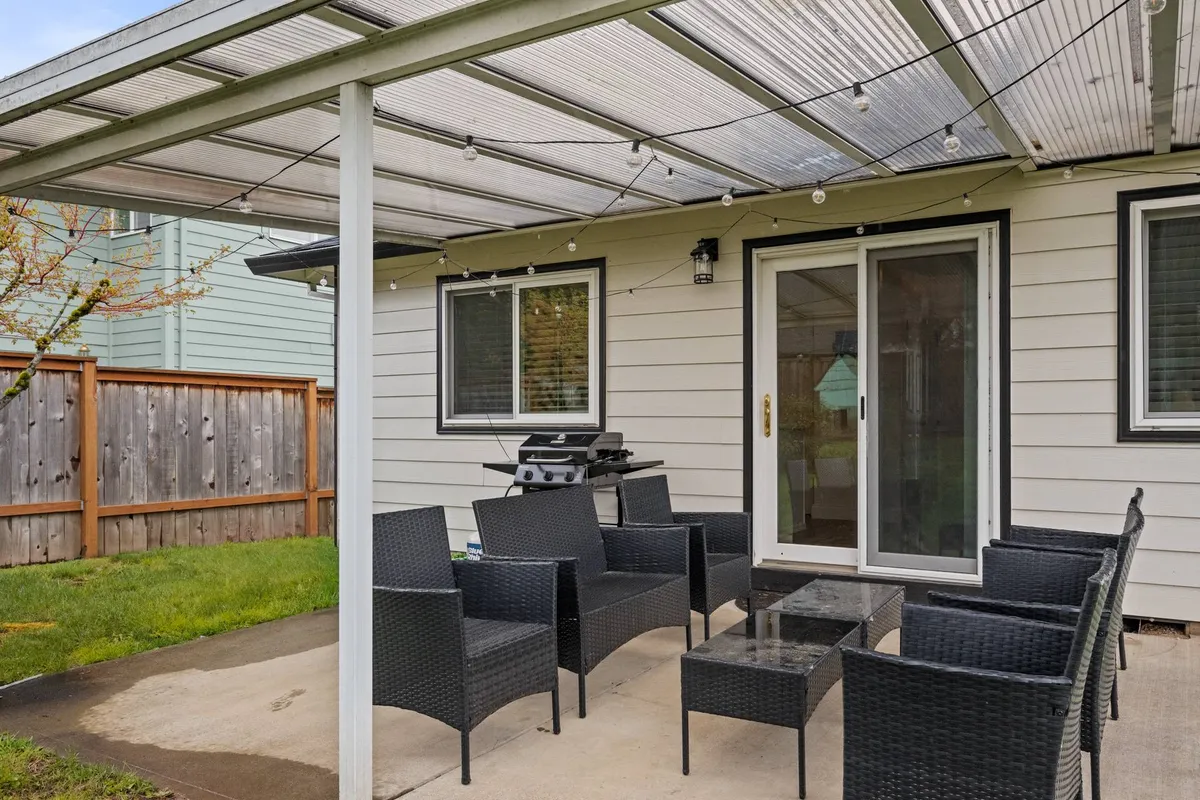 An inviting outdoor seating area featuring a grill and glass table, set up for barbecuing and relaxed socializing. The scene suggests sunset dinners, celebrations with friends, and quiet afternoons spent outdoors.