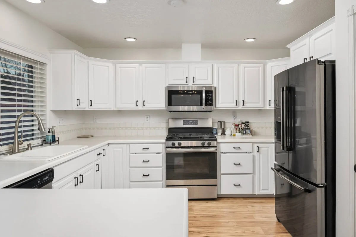 A bright, functional kitchen equipped with stainless steel appliances and ample countertop space, creating a welcoming environment for group meals, family gatherings, or quick snacks between games.