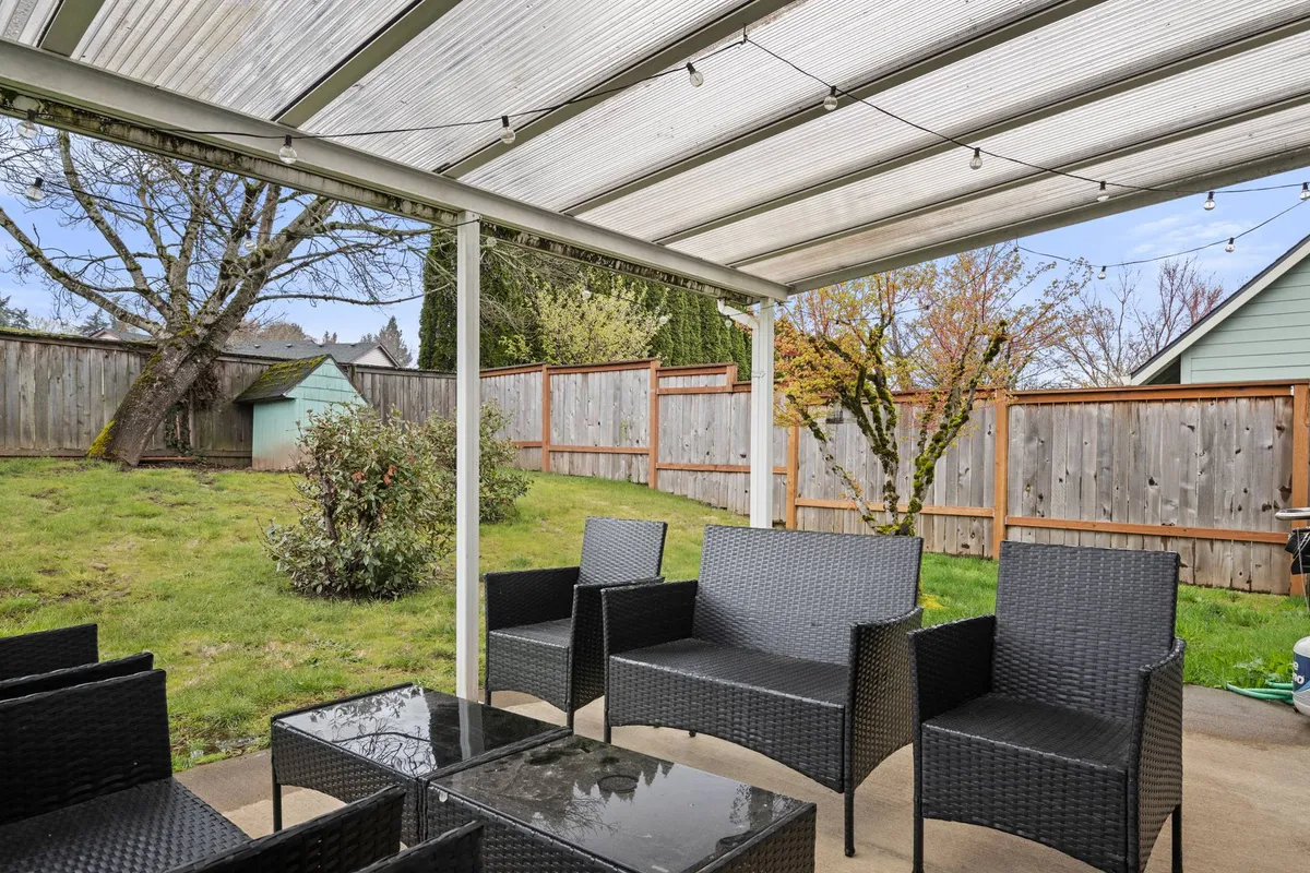 This image captures a glass-top outdoor table surrounded by lush backyard greenery. It evokes a sense of relaxation and connection with nature, ideal for morning coffee or quiet contemplation while pets or kids play safely nearby.